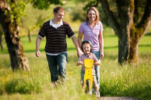 Spaziergang der Familie mit Kind und Laufrad